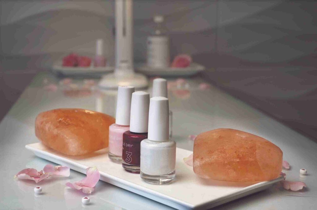 A romantic breakfast setup featuring a heart-shaped egg, pastries, strawberries, flowers, and a cup of cappuccino on a wooden tray.