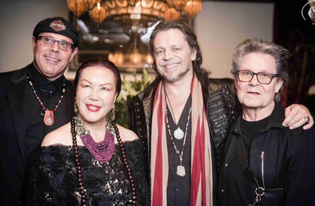 An elaborately decorated room with a Middle Eastern theme, featuring a red velvet sofa, ornate fireplace, intricate rugs, and rich textiles.