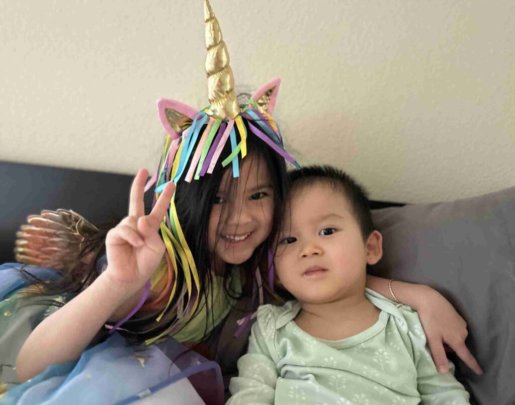 A plate of three pieces of sushi adorned with garnishes and sauce presented on a wooden table.