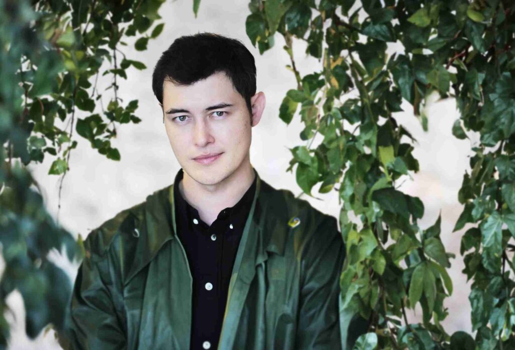 A man in a suit smiling on the cover of  David's Guide  magazine, titled  On The Brink of Greatness. 