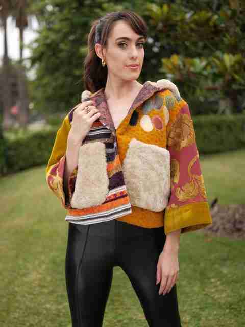 An elegant dining room with white tablecloths, red chairs, chandeliers, large windows, and ornate decor.