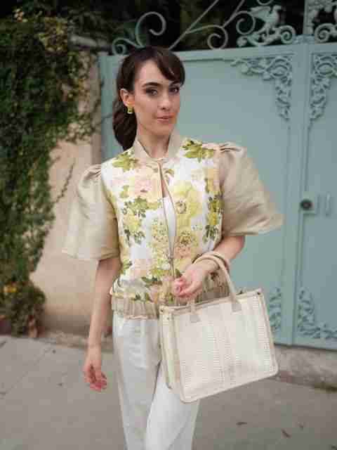 An elegant dining room with white tablecloths, red chairs, chandeliers, large windows, and ornate decor.