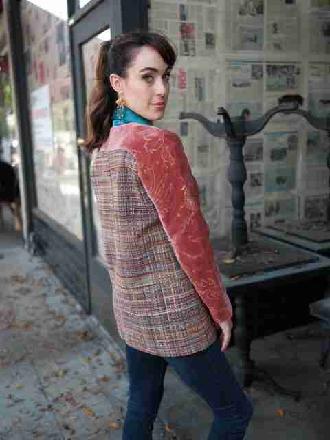 An elegant dining room with white tablecloths, red chairs, chandeliers, large windows, and ornate decor.