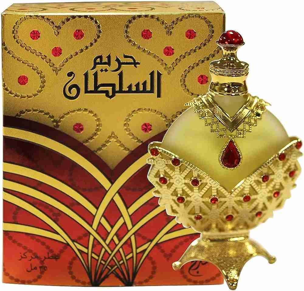 An ornate perfume bottle with a traditional Arabic design next to its matching packaging box.
