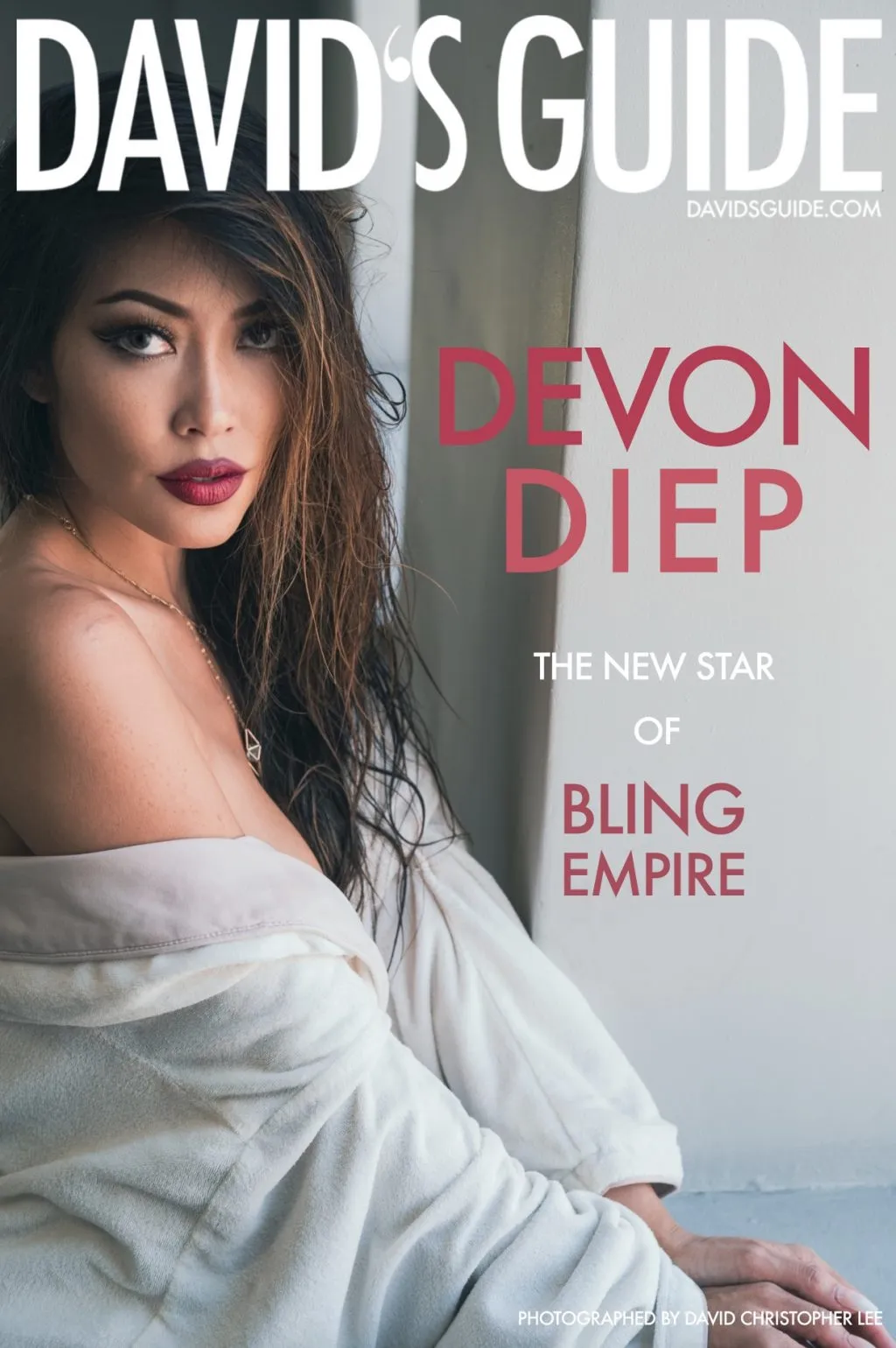 A woman with long dark hair looks over her shoulder with an intense gaze near a blurred foreground element.