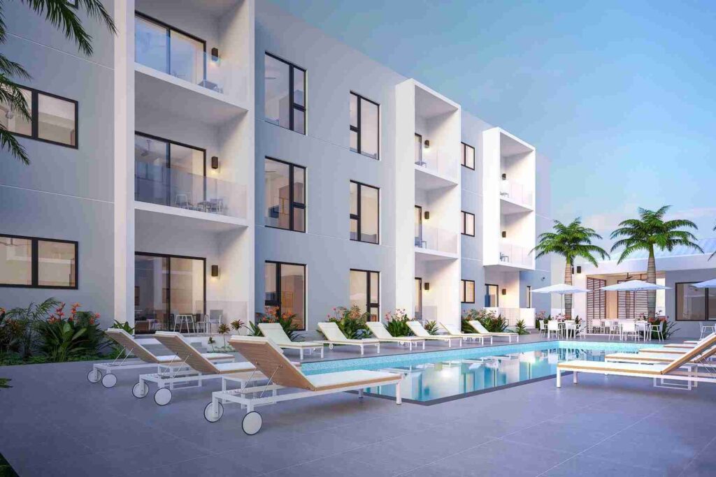 A modern apartment building with a swimming pool and loungers in a clean, well-lit setting, suggesting a luxurious living space.