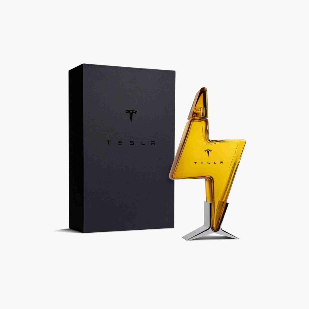 A shiny, gold-colored, Tesla-branded trophy with an abstract design on a white background.