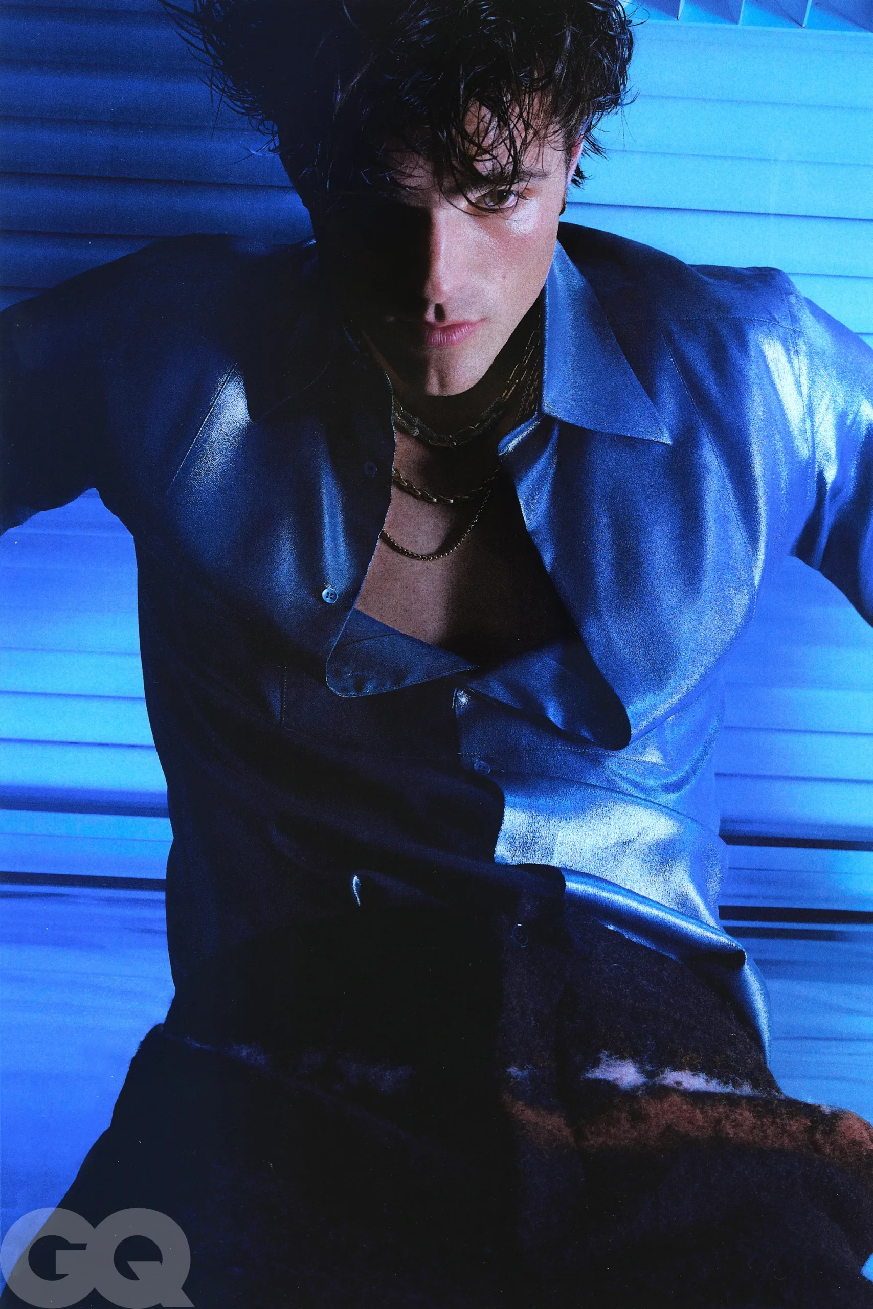 An elegant dining room with white tablecloths, red chairs, chandeliers, large windows, and ornate decor.