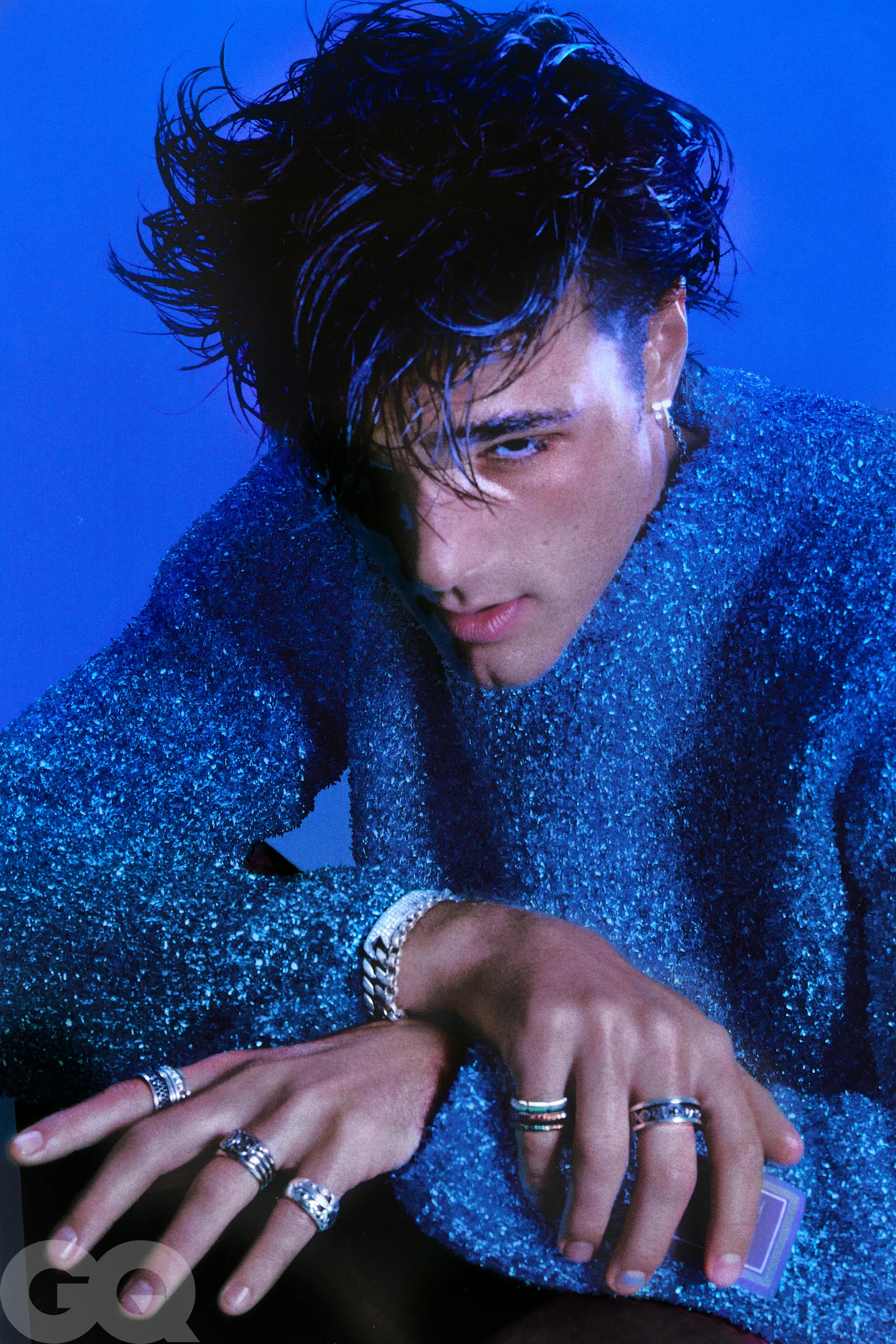 An elegant dining room with white tablecloths, red chairs, chandeliers, large windows, and ornate decor.