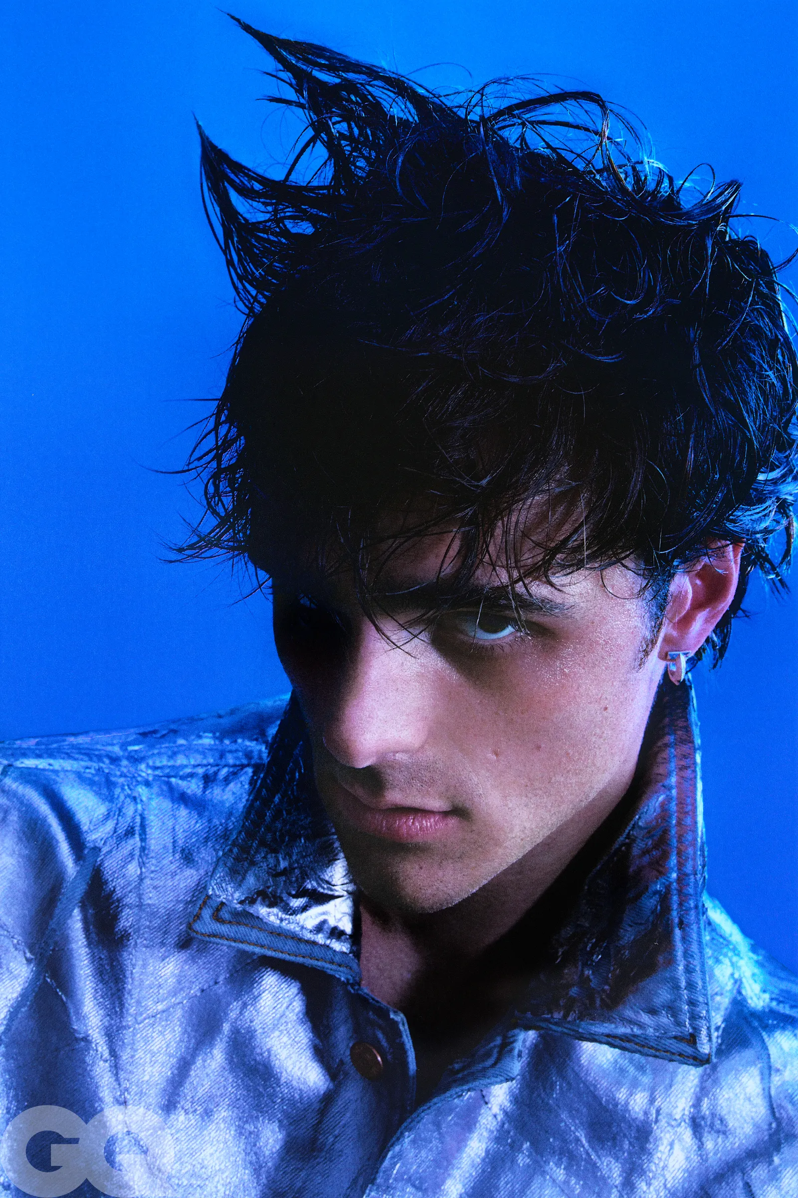 An elegant dining room with white tablecloths, red chairs, chandeliers, large windows, and ornate decor.