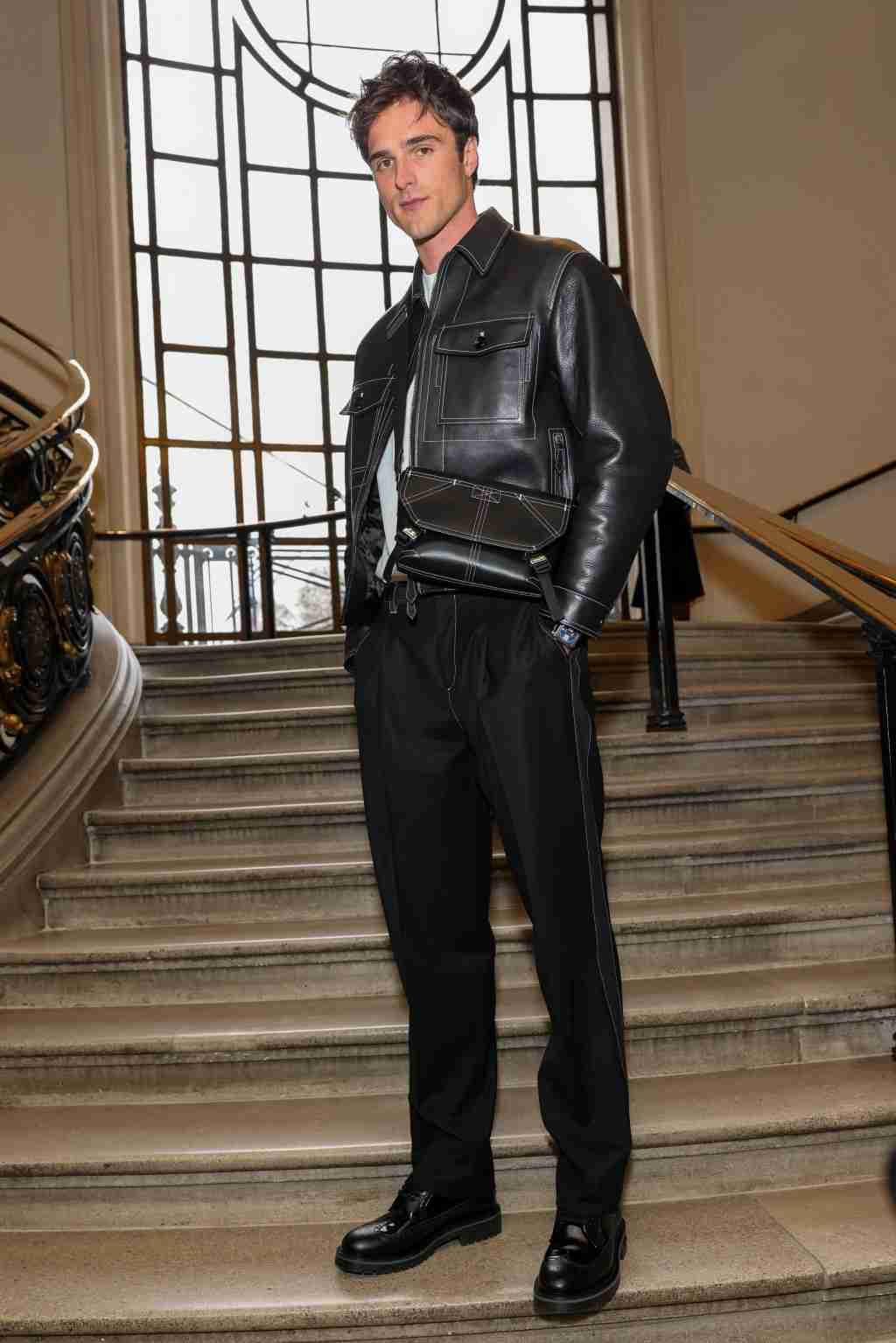 An elegant dining room with white tablecloths, red chairs, chandeliers, large windows, and ornate decor.