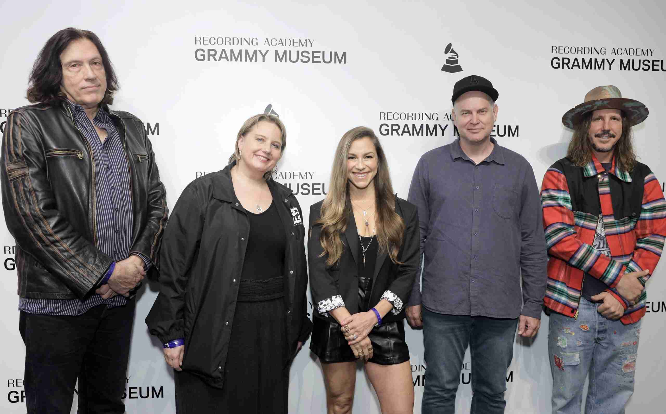 Five individuals posing together in front of a backdrop with the Recording Academy and Grammy Museum logos.