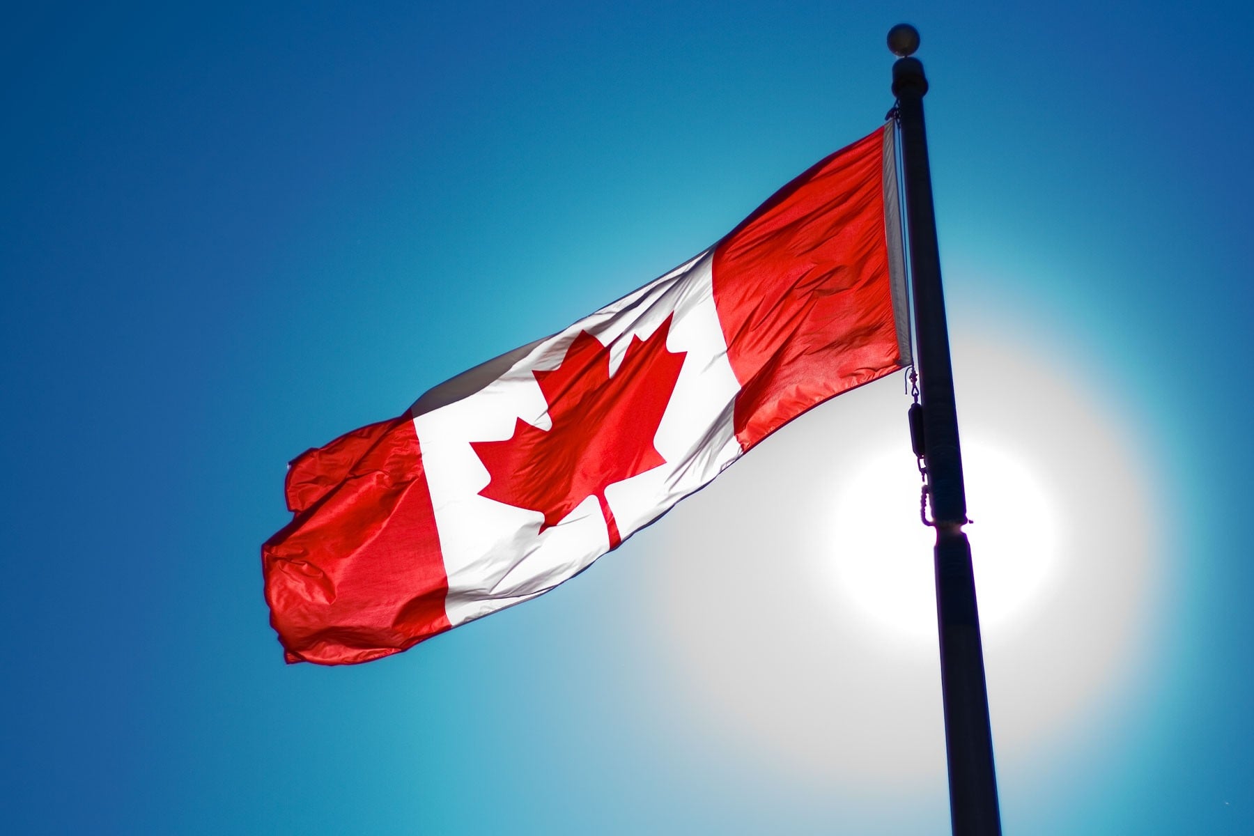 Canadian flag waving against a blue sky