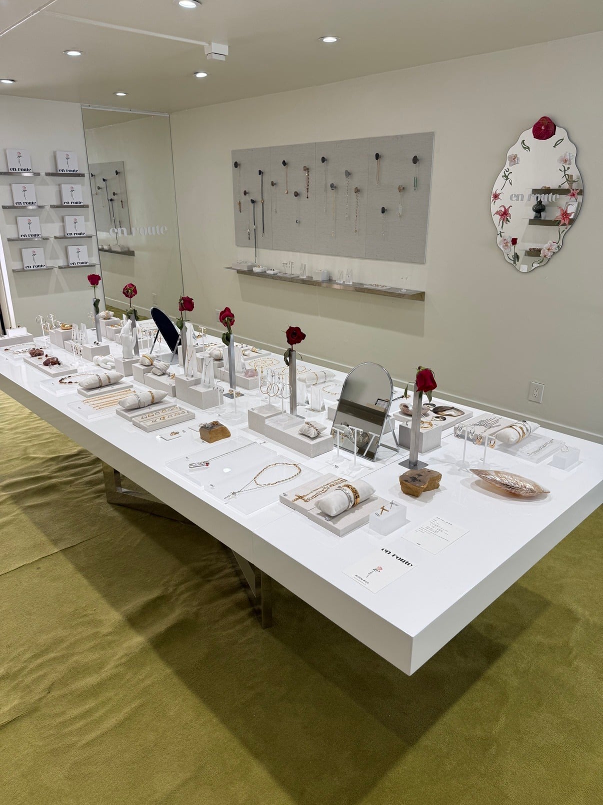 en route jewelry pop-up shop interior with white display tables and the signature en route mirror