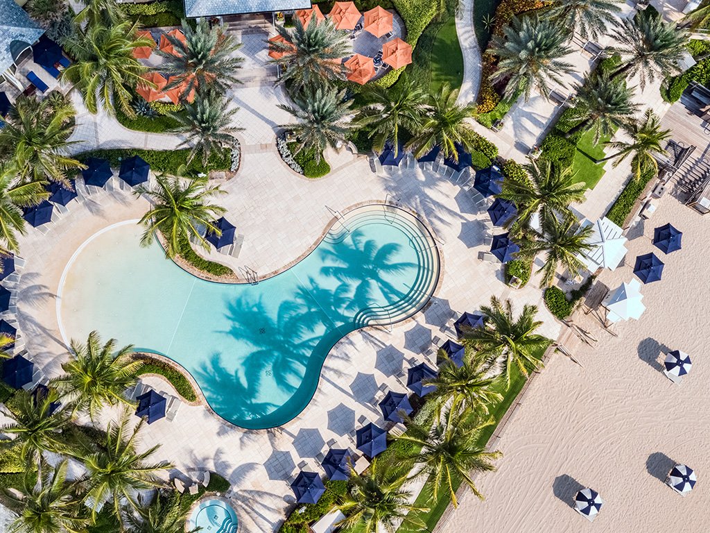 Aerial view of the Beach Club pool deck at The Breakers Palm Beach above the private beach