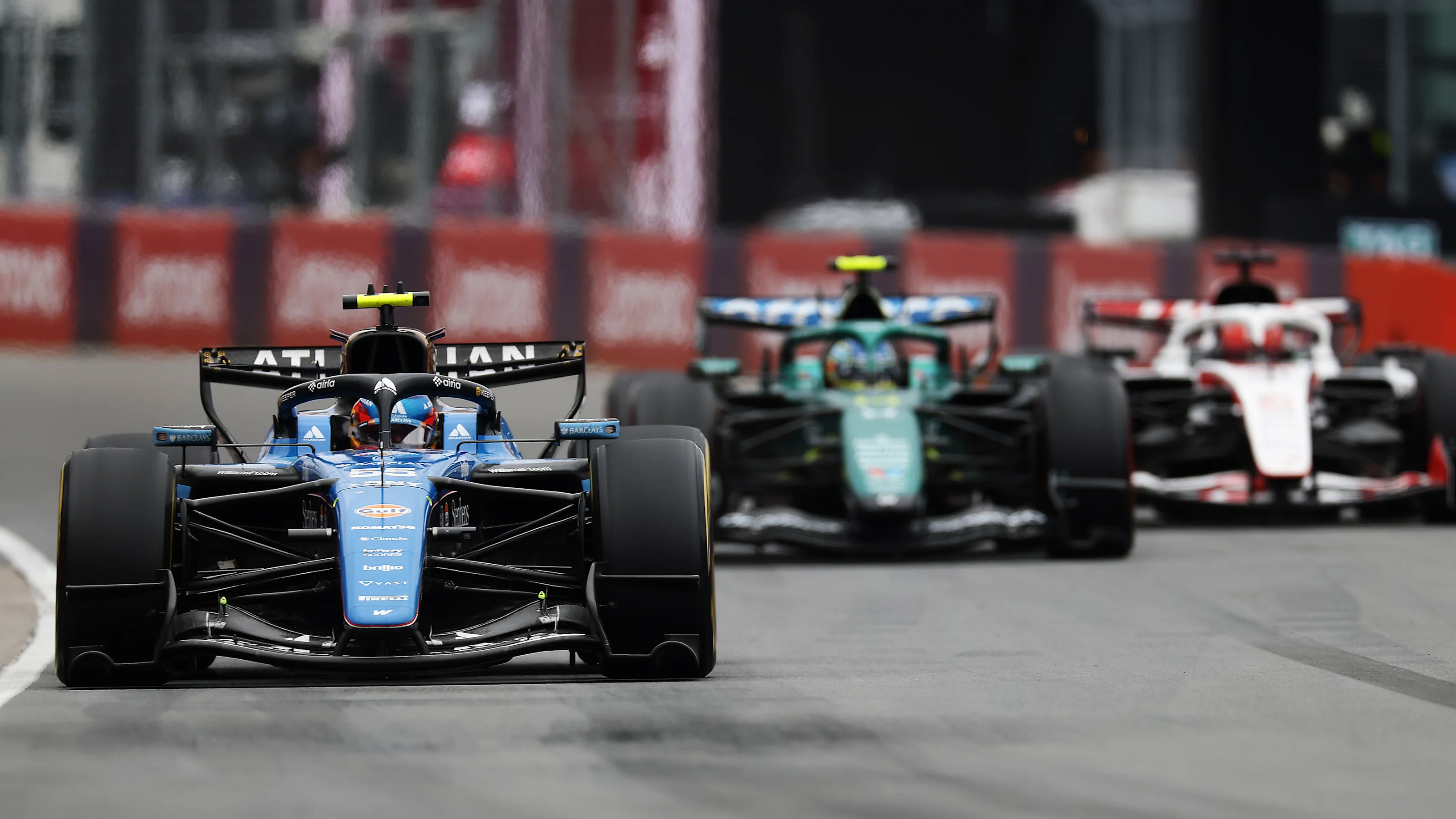 A Williams leads an Aston Martin and a Haas through a corner at the Circuit Gilles-Villeneuve, with Ollie Bearman fighting through to tenth for Haas in Montreal.