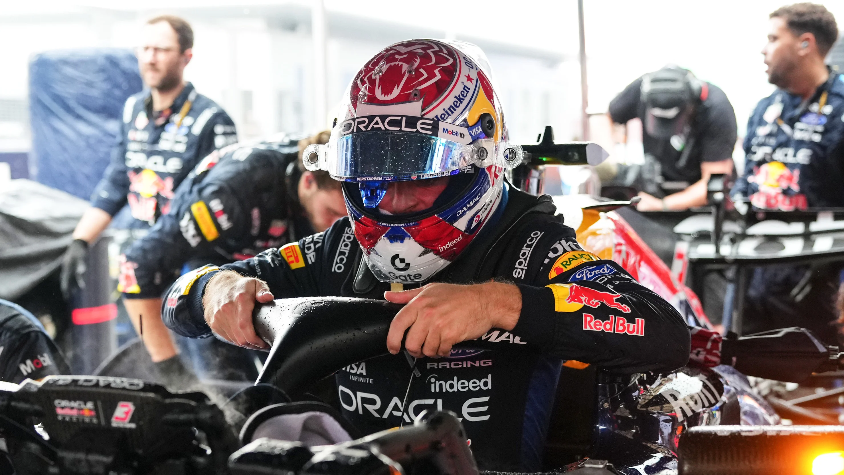 Max Verstappen of Oracle Red Bull Racing climbs into his car in the rain at Sepang before the Bahrain Grand Prix in Malaysia on October 4, 2026.