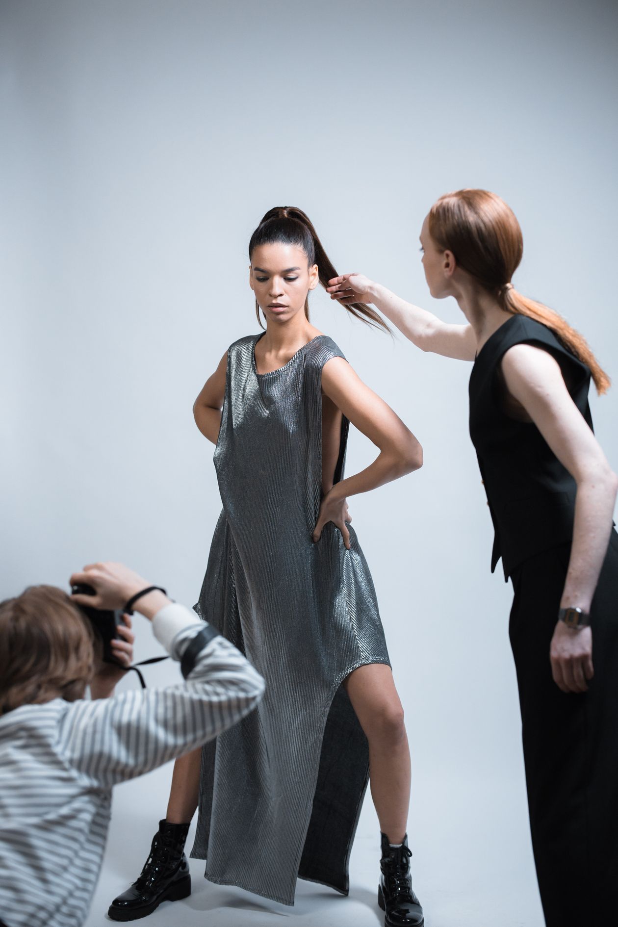 Stylist adjusting a model's hair between shots on a Los Angeles fashion set