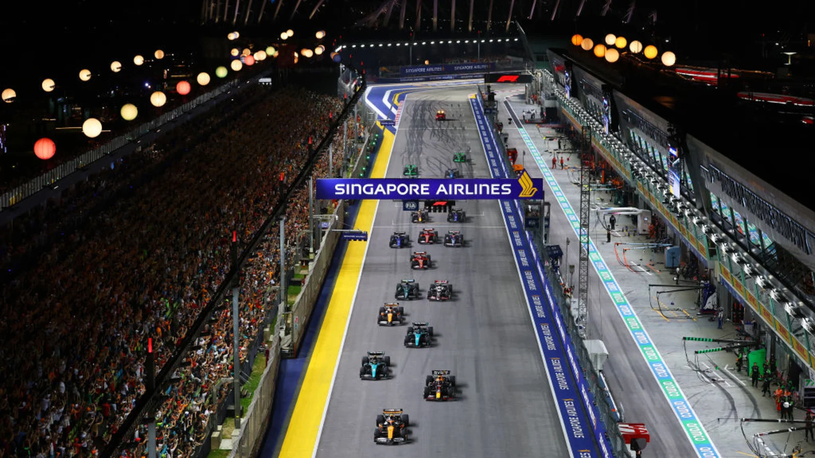 Cars racing under the lights at the 2024 Singapore Grand Prix.