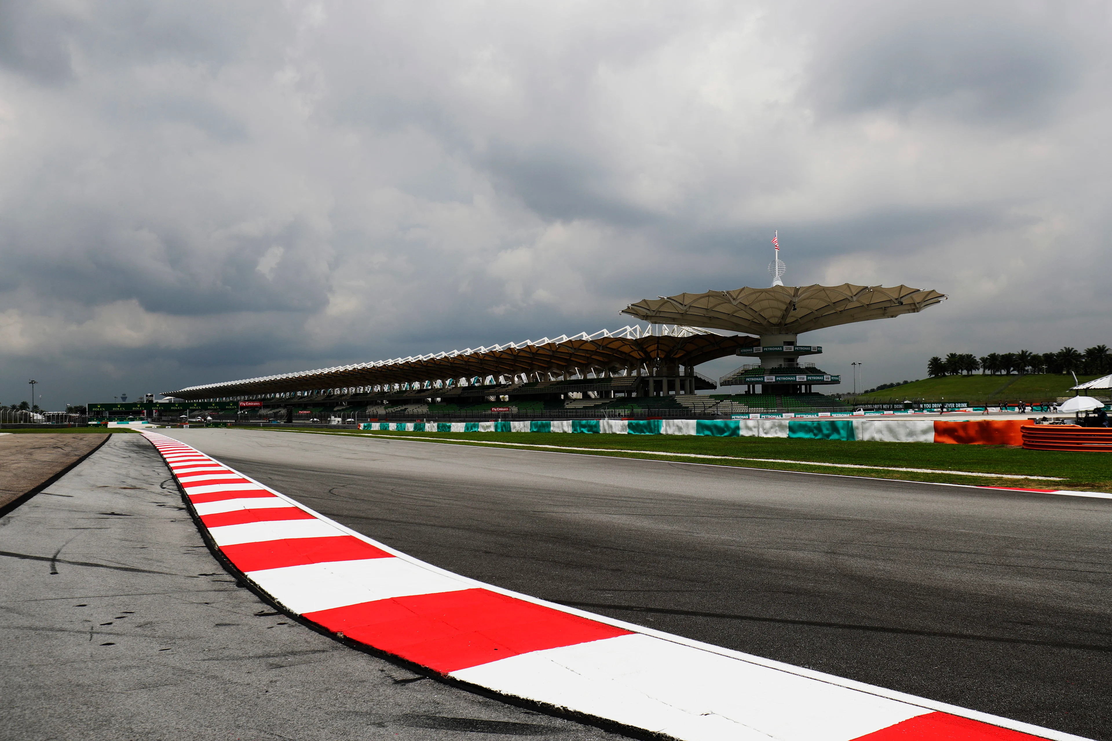 ** Sepang International Circuit's main straight and grandstand under storm clouds.