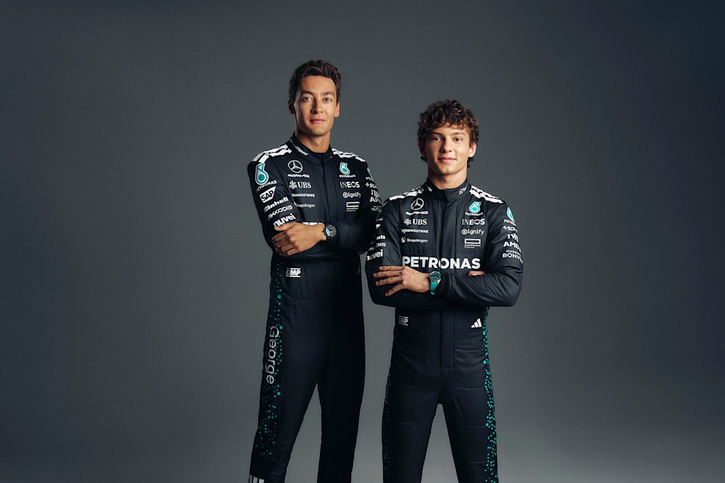 George Russell and Kimi Antonelli pose in their Mercedes-AMG PETRONAS F1 Team race suits in an official team portrait.
