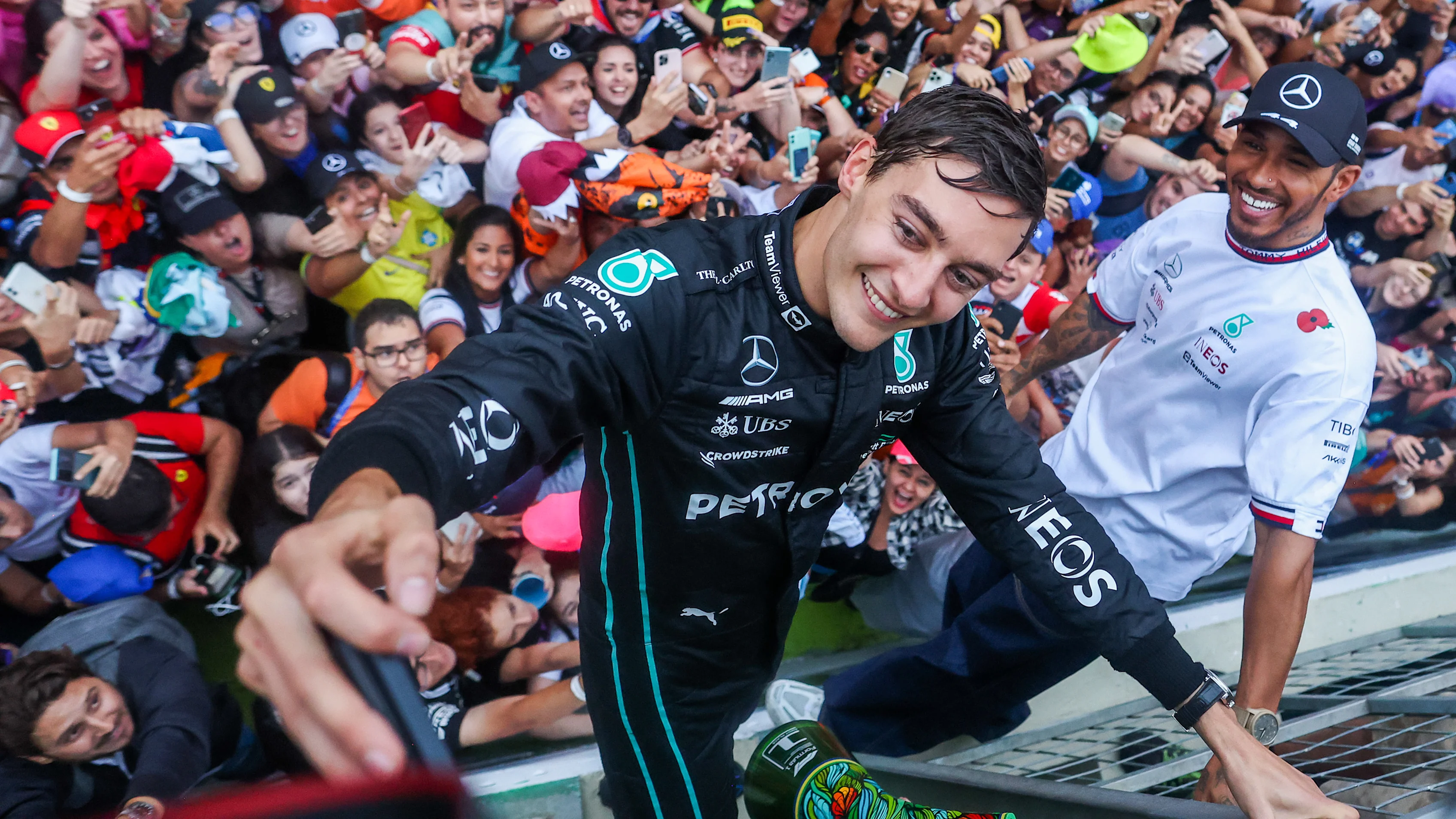 George Russell celebrates his maiden Grand Prix victory at the 2022 Sao Paulo Grand Prix in Brazil, with Lewis Hamilton alongside.