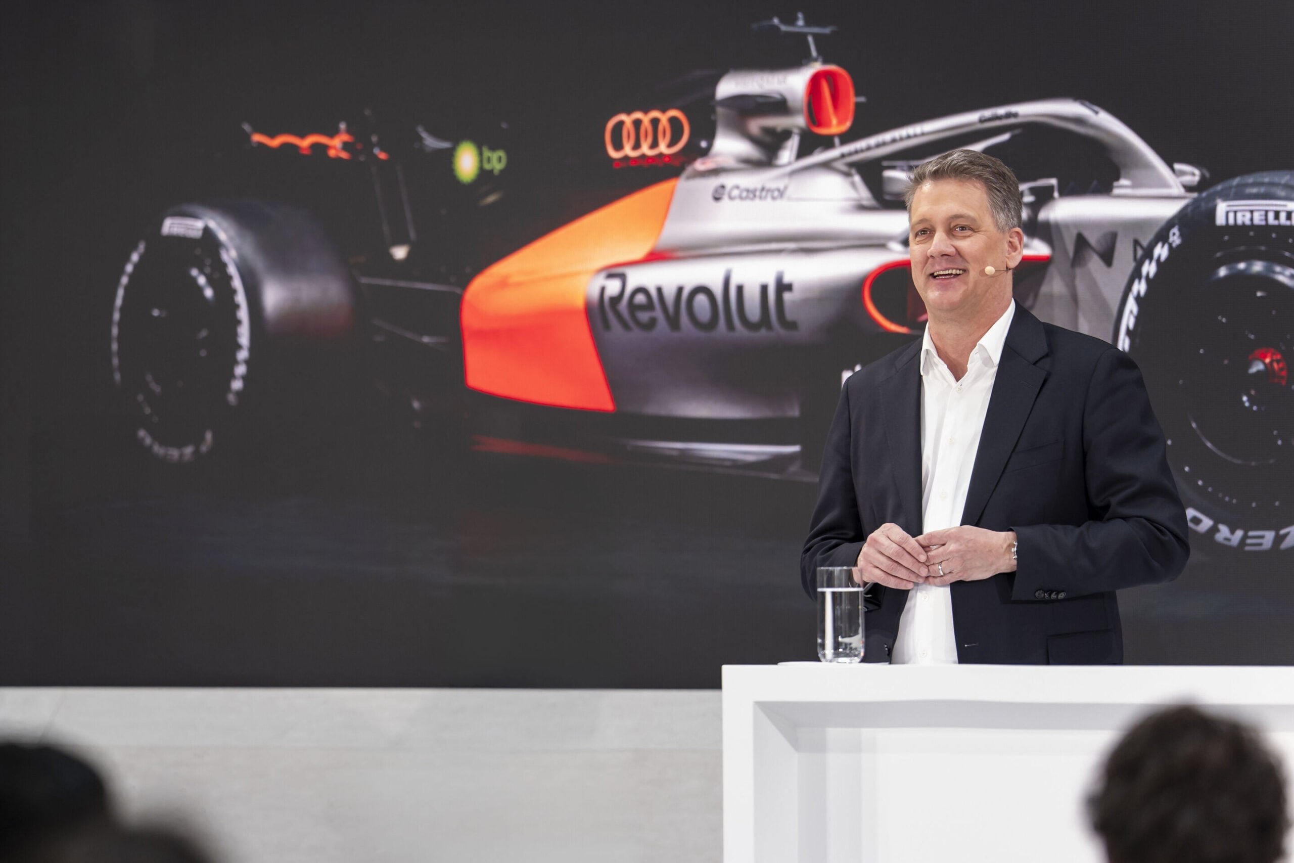 Audi CEO Gernot Döllner speaking at a podium