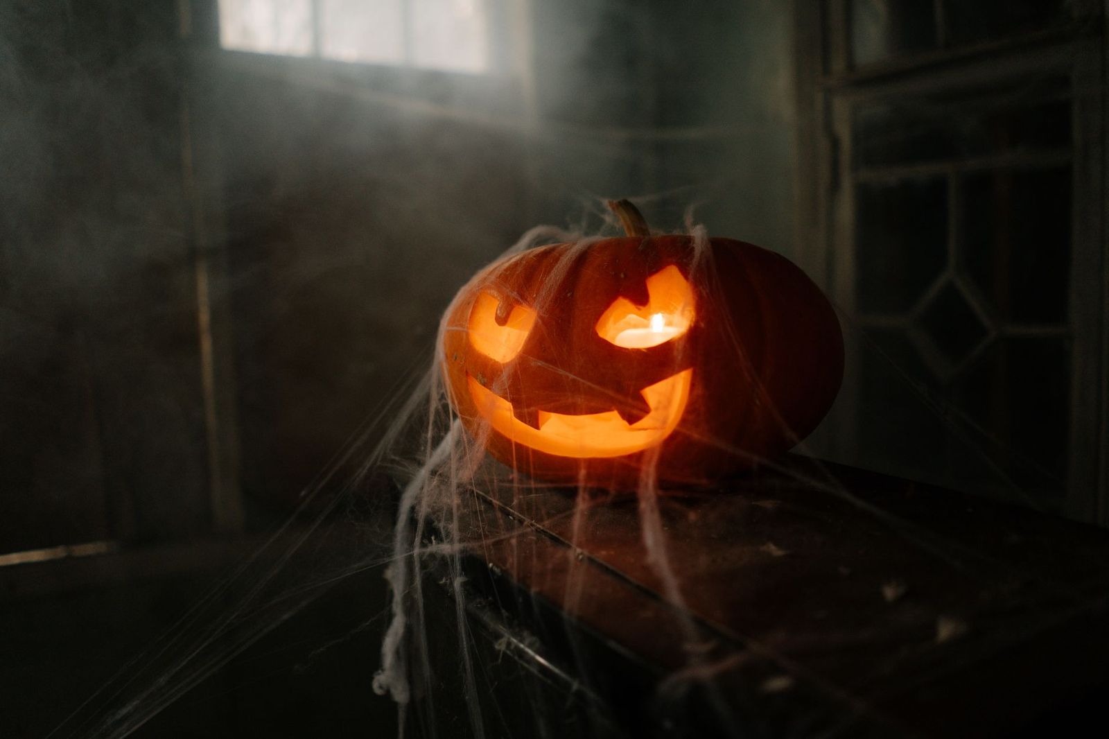 Glowing jack-o-lantern in a dark foggy room, Halloween season at the best haunted houses in Los Angeles