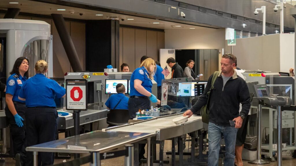 Travelers moving through a TSA airport security checkpoint