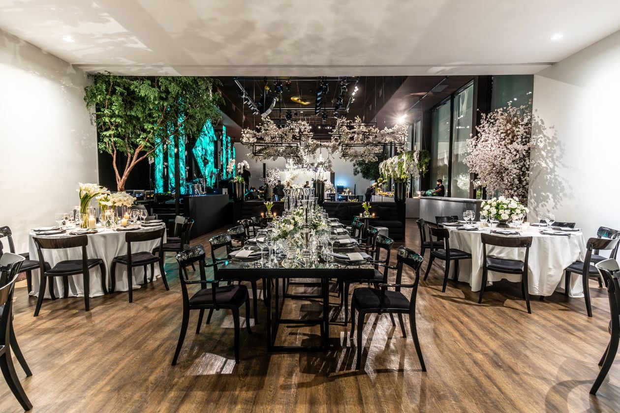 Luxurious Los Angeles hotel ballroom set for an opulent evening celebration, with floral centerpieces and formal place settings on every table.