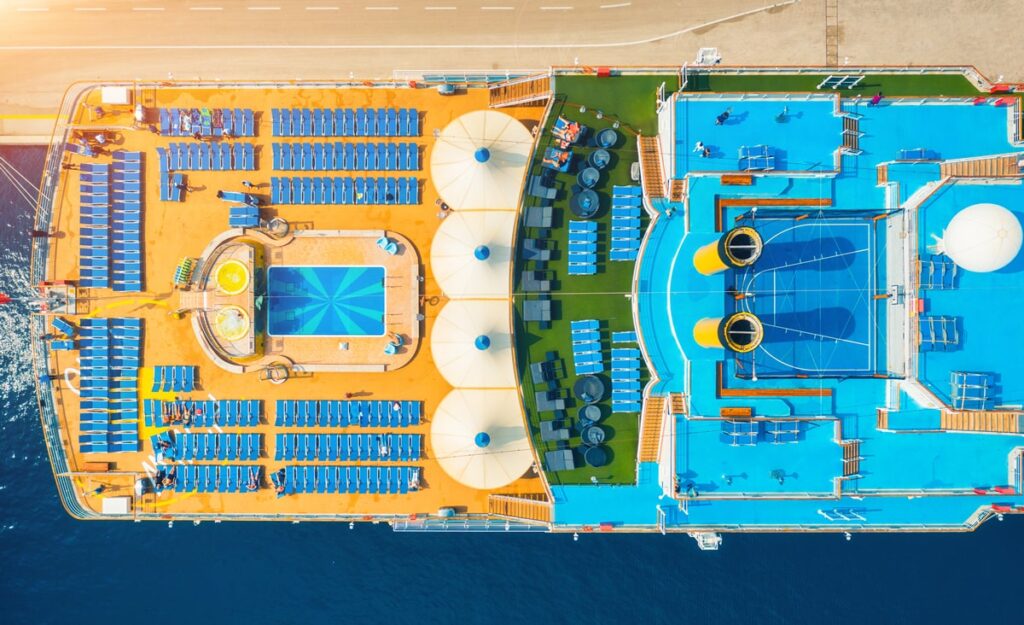 Cruise ship pool deck with loungers and palm trees