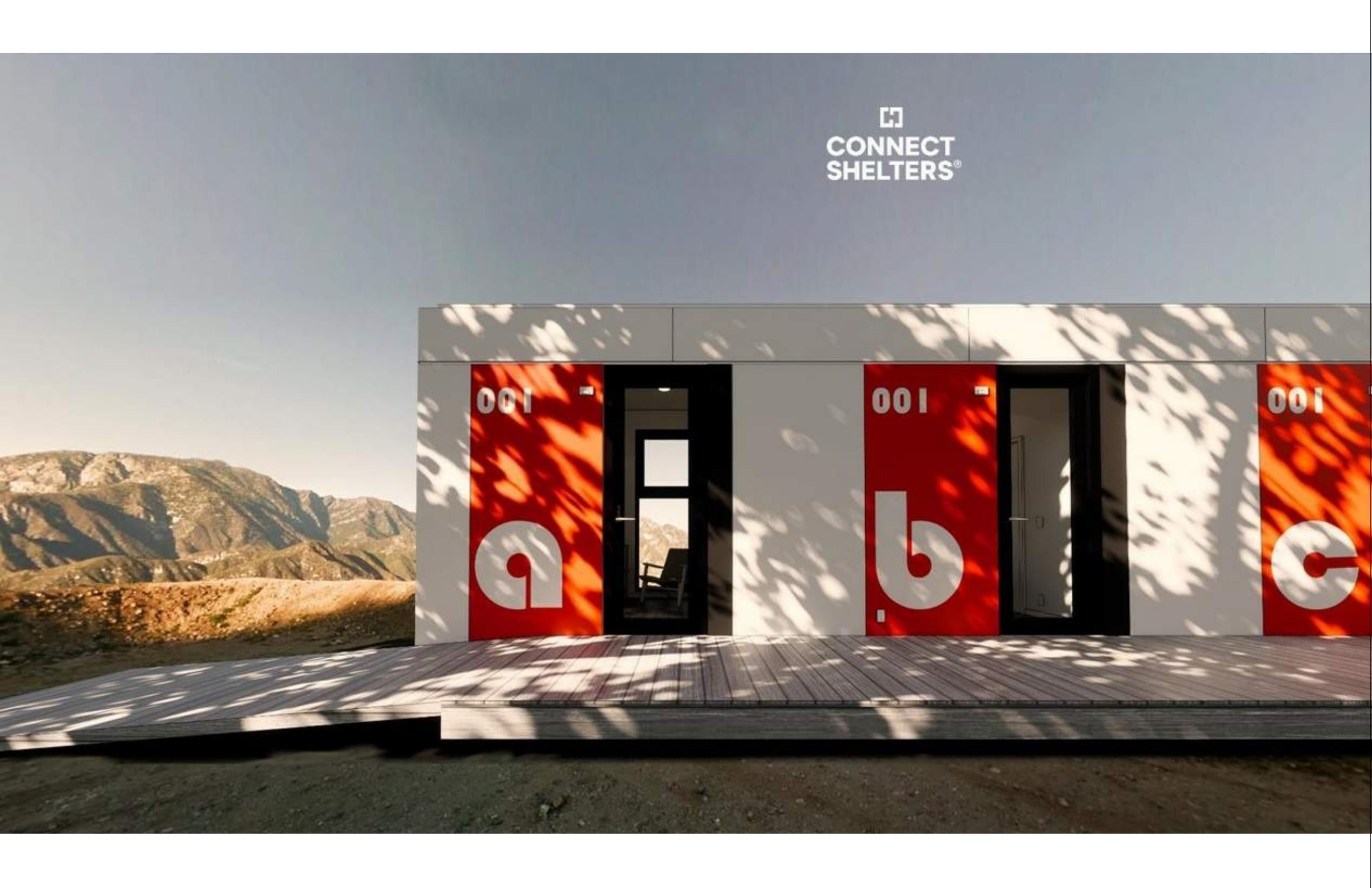 A row of Connect modular housing units with signature red doors in a mountain setting