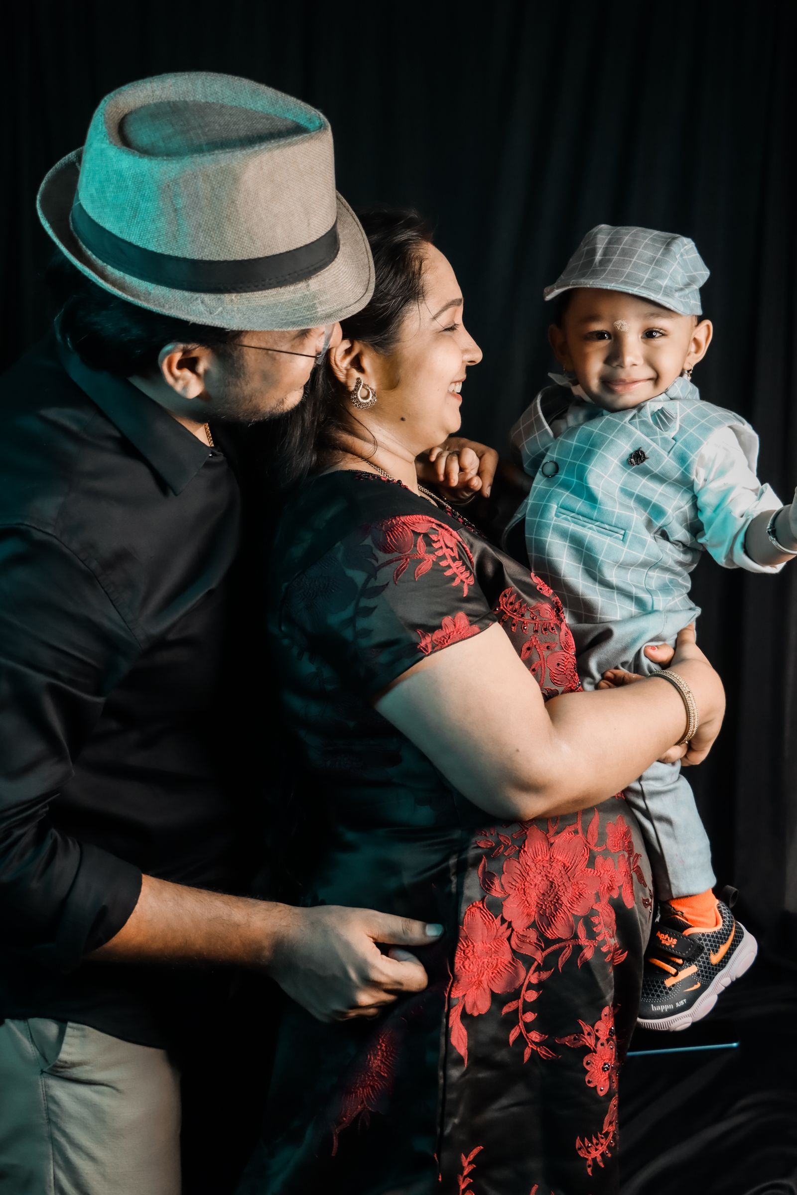 Parents with their smiling baby boy in stylish outfits for family photos