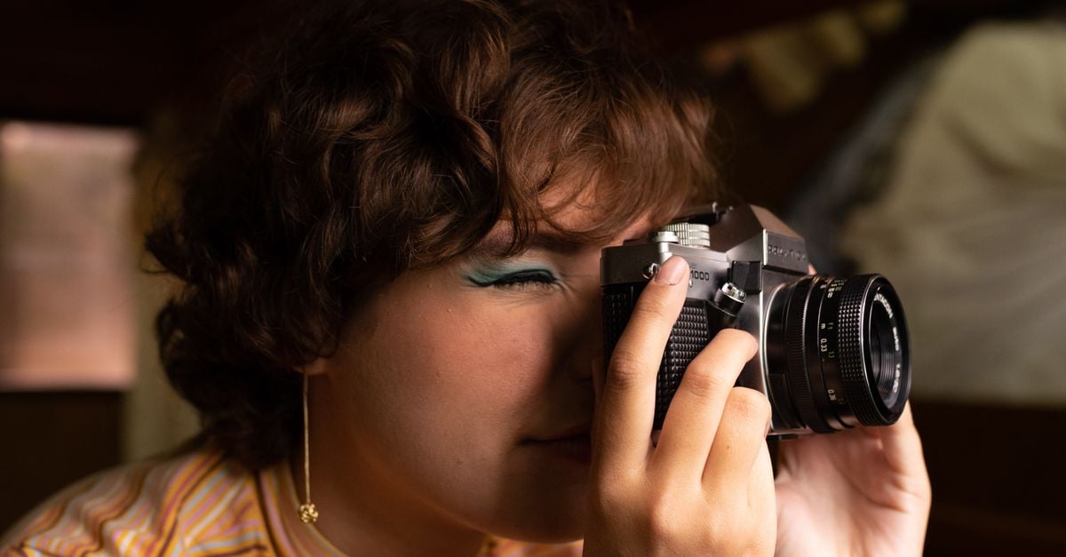 Portrait photographer holding a camera during an outdoor session