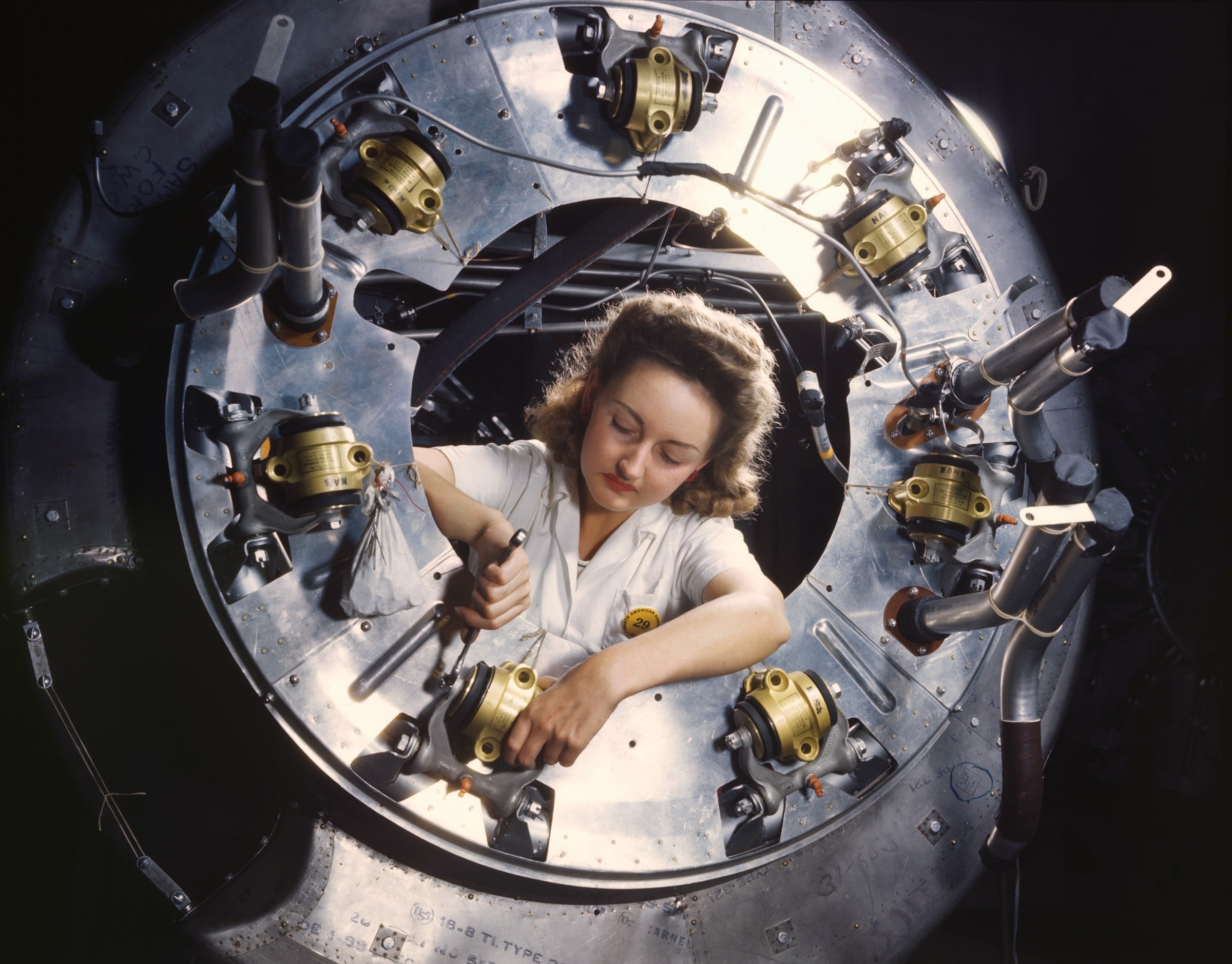 Factory worker assembling a B-25 bomber engine cowling in 1942