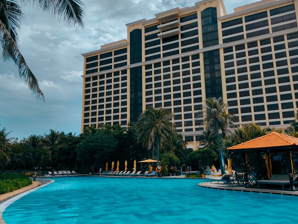 Luxury resort building with tropical poolside view and palm trees