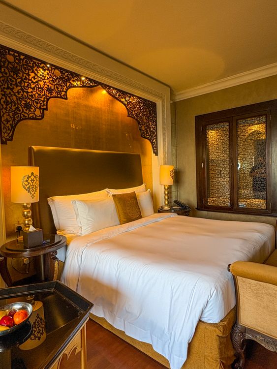 Luxury hotel room interior in Dubai with ornate decor and plush bedding
