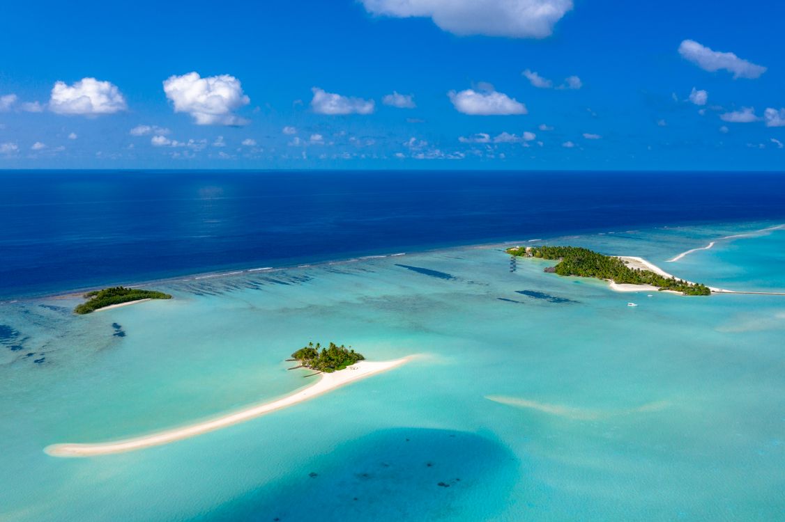 Aerial view of tropical islands and turquoise lagoons in the Maldives