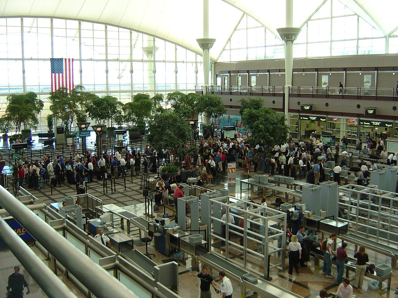 Travelers waiting in long airport security screening lines at a busy terminal