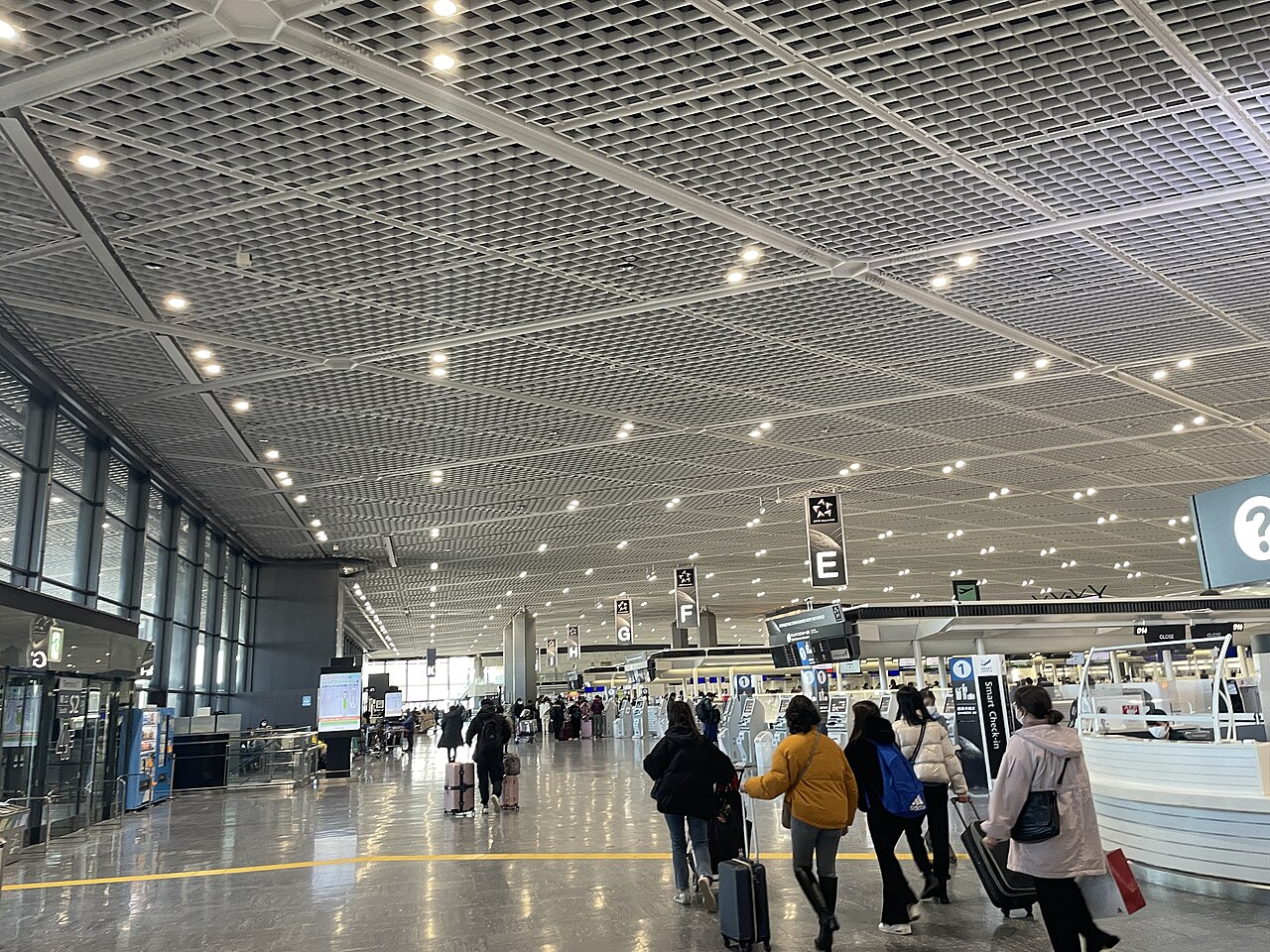 Travelers walking through the bright interior of Narita International Airport Terminal 1