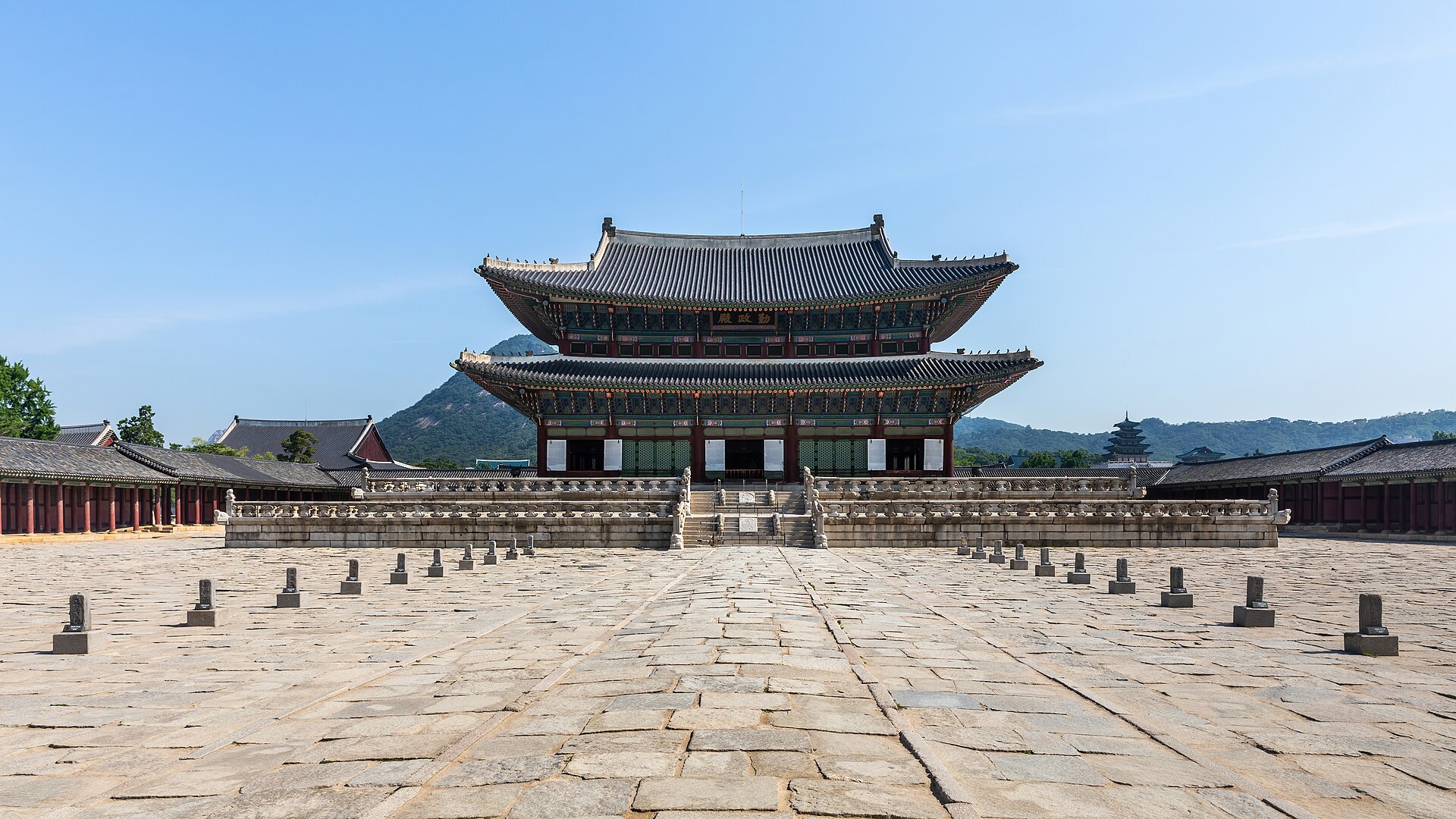 Geunjeongjeon, the Imperial Throne Hall at Gyeongbokgung Palace in Seoul, with its curved tiled roofs under a clear blue sky