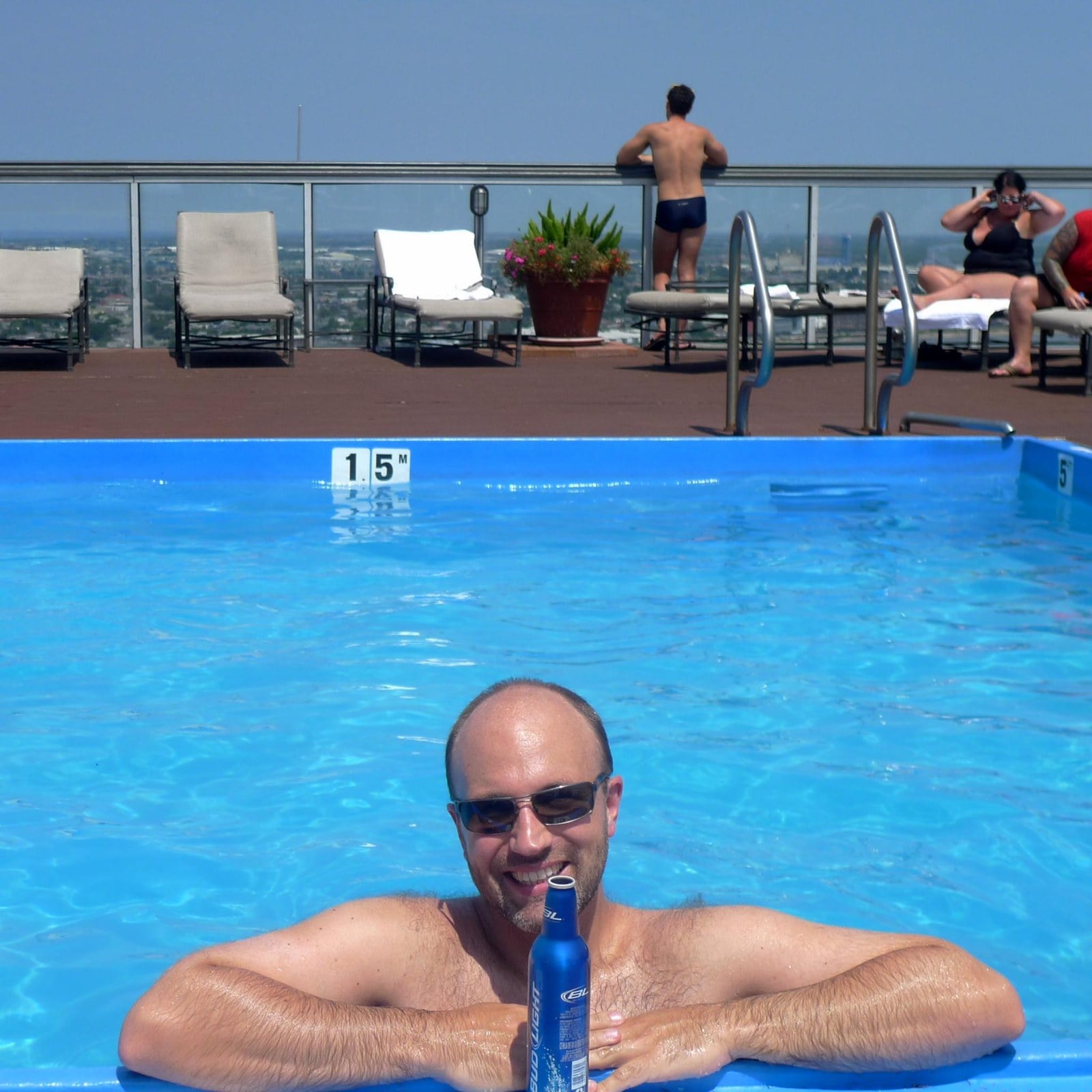Rooftop swimming pool with lounge chairs and city views at a hotel