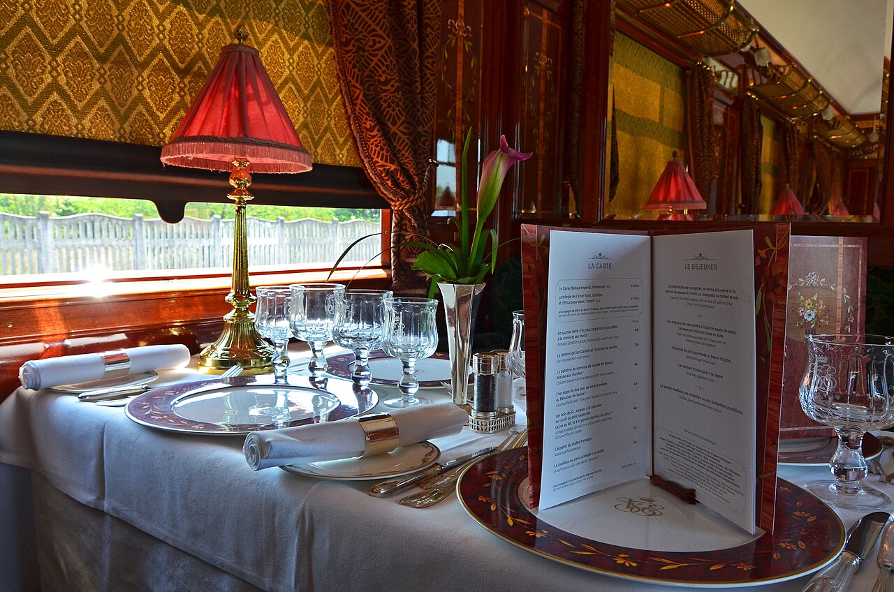 Art deco restaurant car with set tables aboard a luxury train