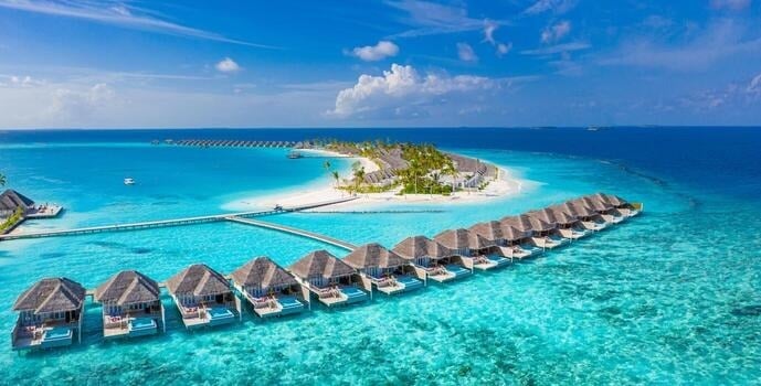 White sand beach with palm trees and crystal clear water in the Maldives