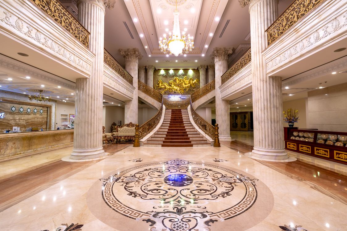 Elegant luxury hotel foyer with grand staircase, marble floors and chandelier