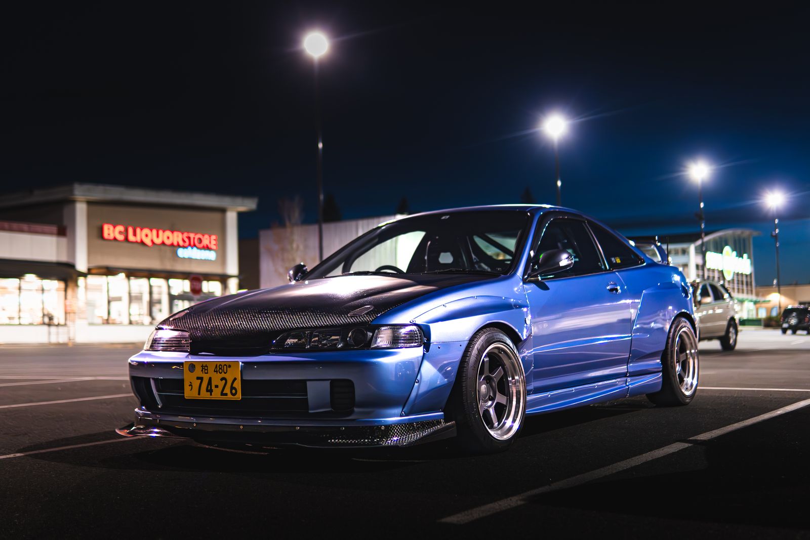 Classic blue Acura Integra coupe at night — the new Acura Integra carries on the nameplate's tuner heritage