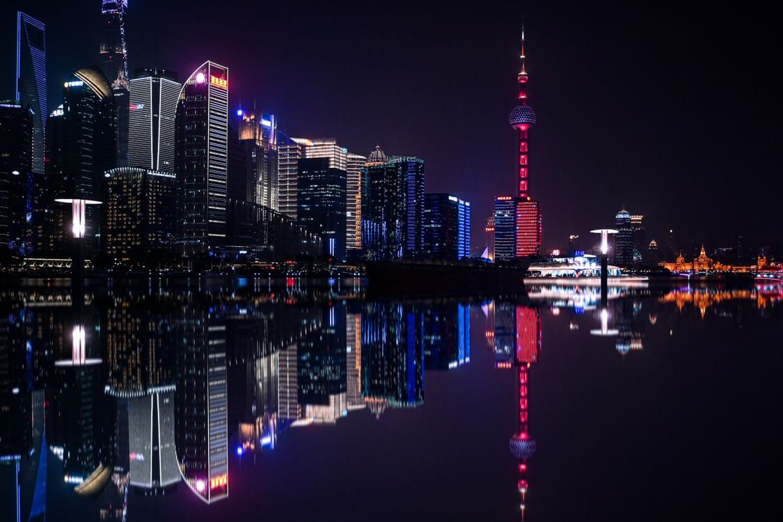 Shanghai city at night with illuminated skyscrapers reflected on the water