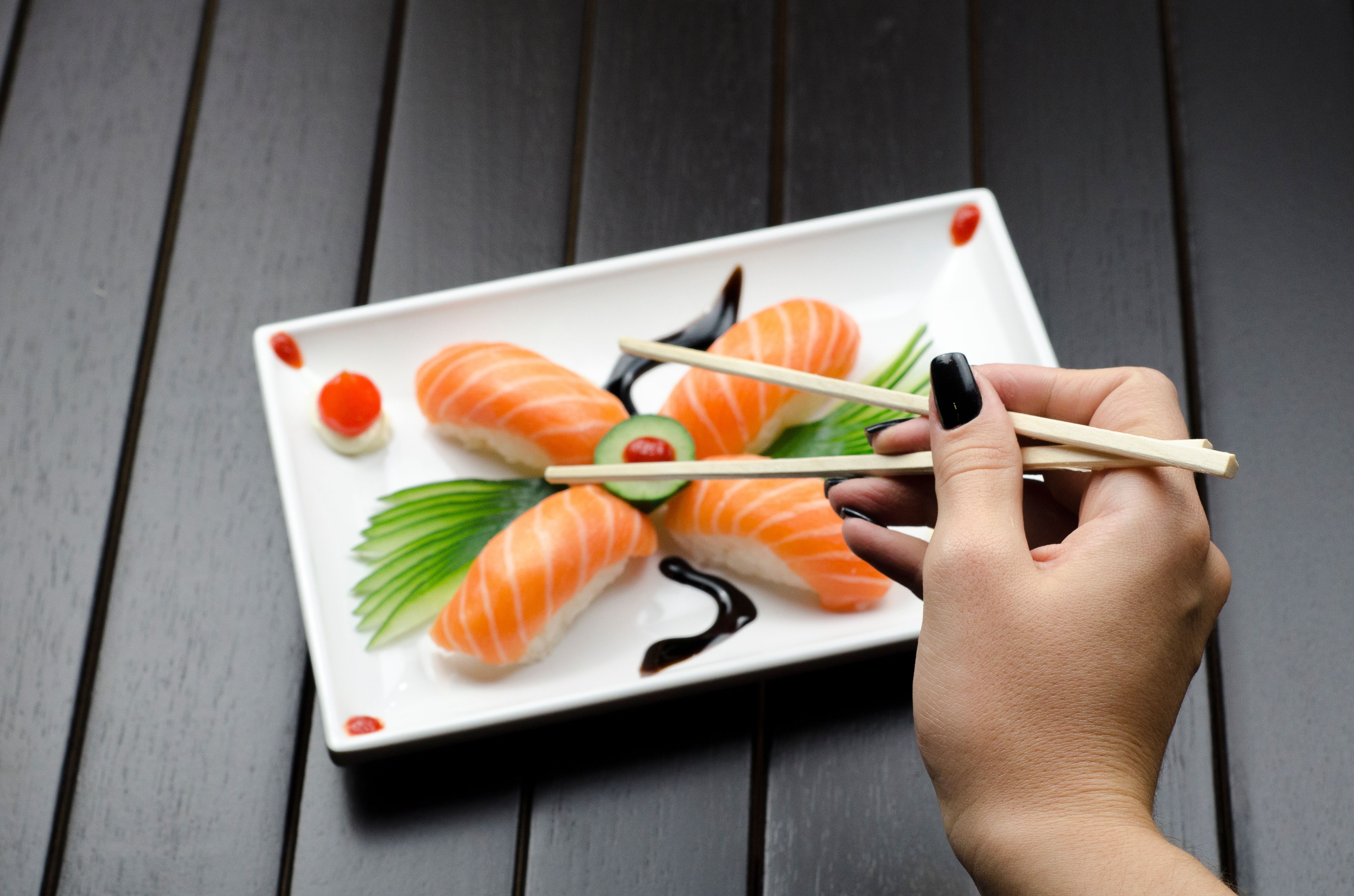Salmon nigiri sushi on a ceramic plate