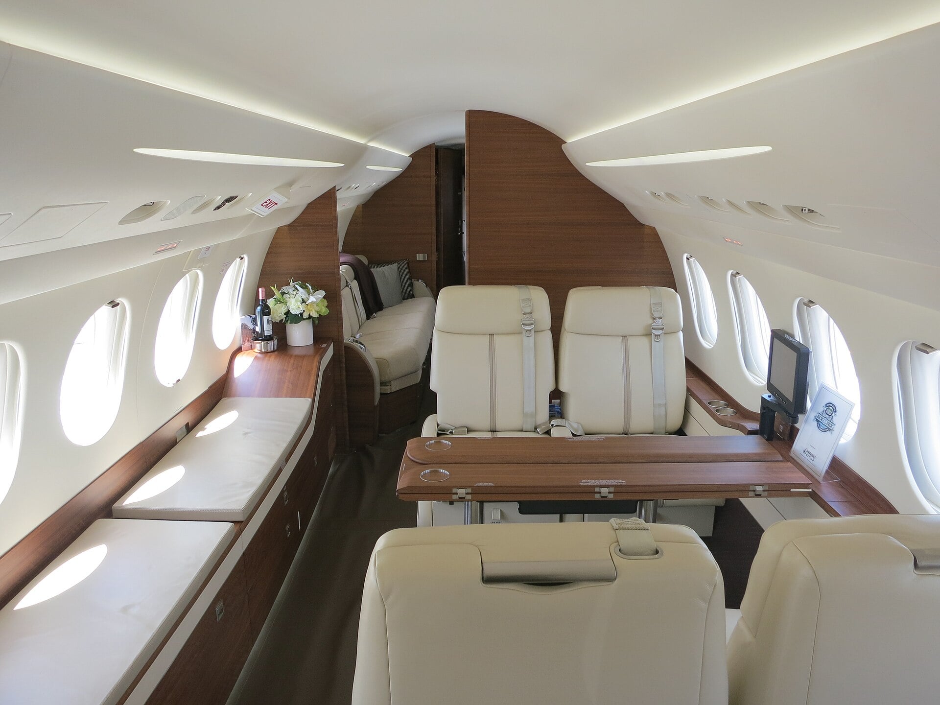 The forward cabin of a Dassault Falcon 7X private jet with cream leather club seats