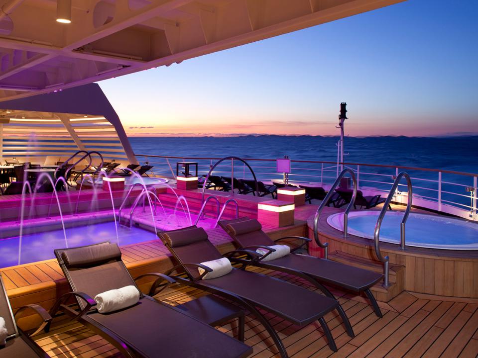 The aft swimming pool deck of the Seabourn Sojourn with rows of shaded loungers